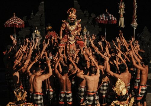 Vibrant Kecak dance ceremony with dancers in traditional attire at night in Bali.